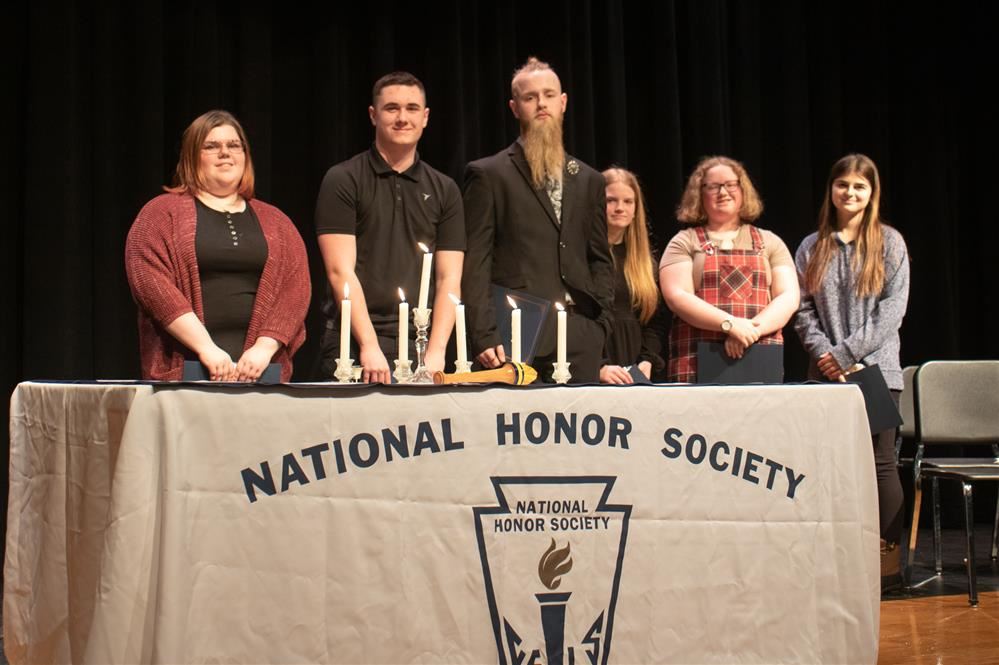  New NHS inductees pose behind a table.